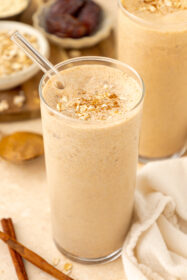 angled photo of oatmeal cookie smoothie in clear glass with a straw