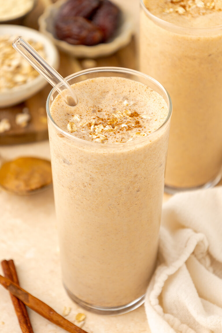 angled photo of oatmeal cookie smoothie in clear glass with a straw
