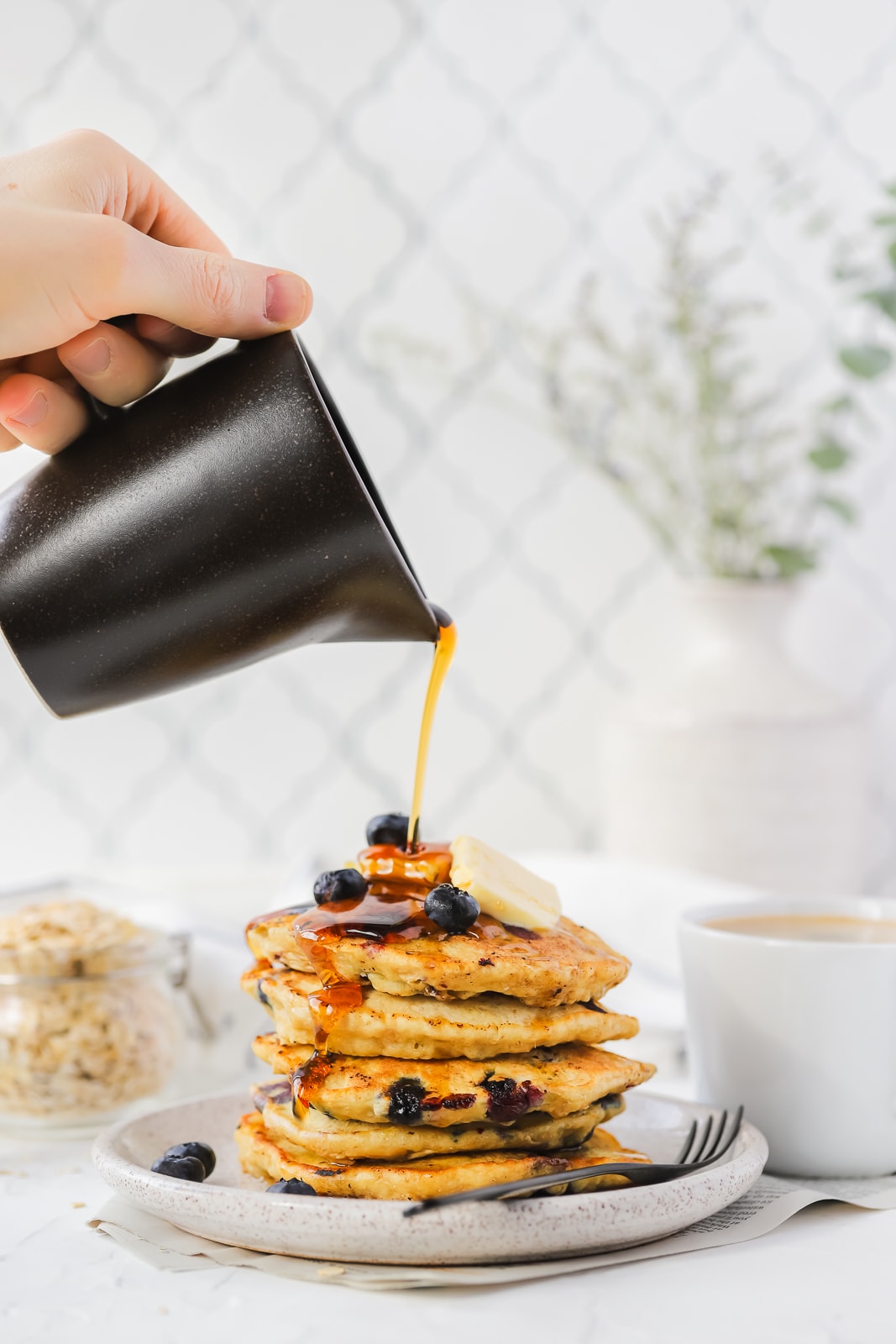 pouring syrup onto pancakes