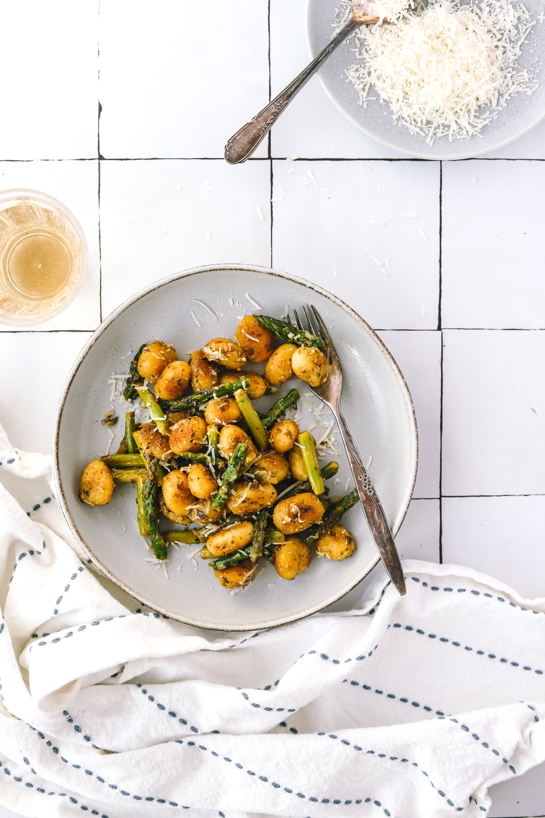 gnocchi in a bowl with a glass of wine
