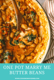 wooden spoon in a pot of cooked butter beans and sundried tomato sauce