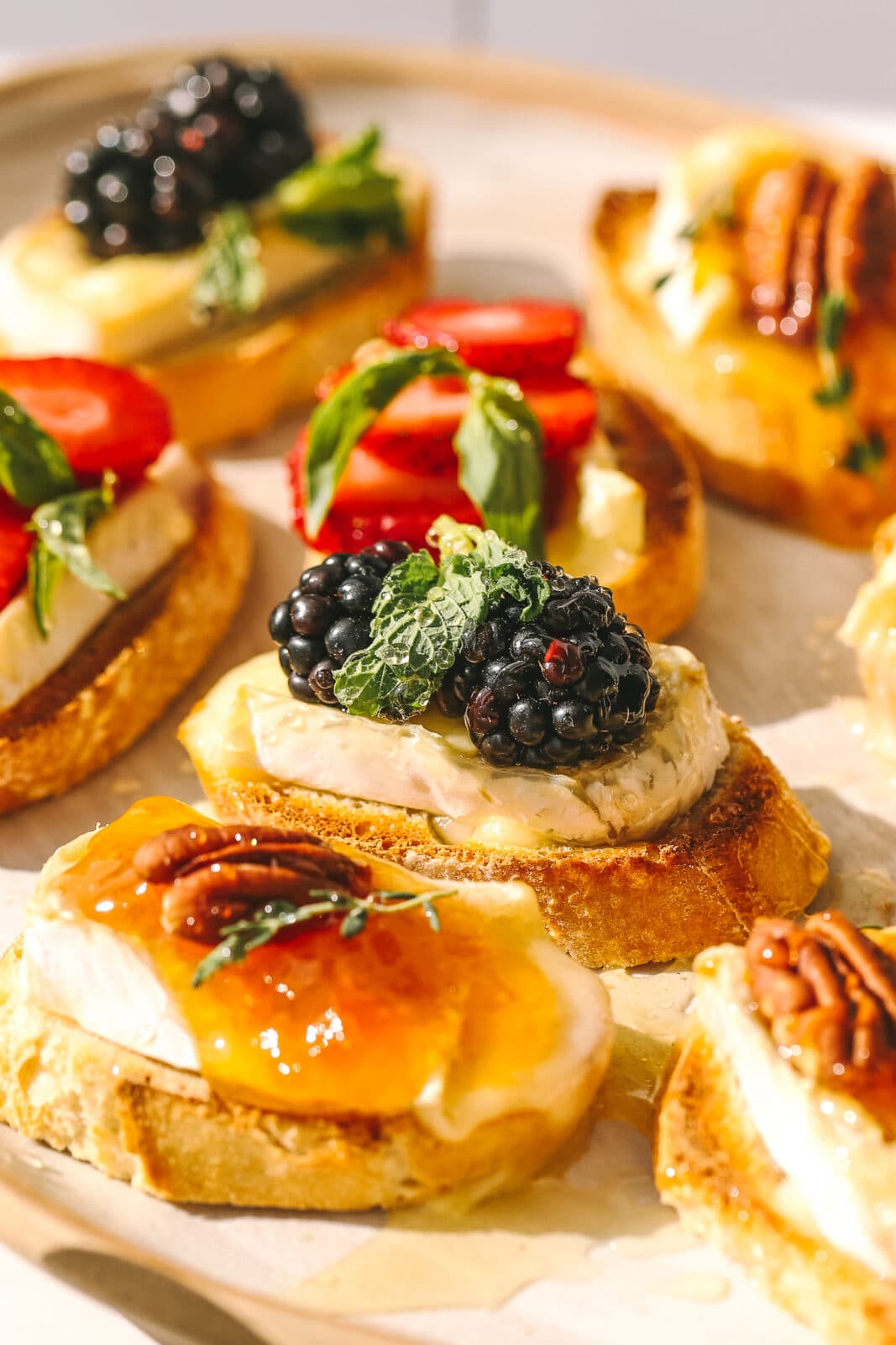side angle close-up of blackberries and brie on a crostini