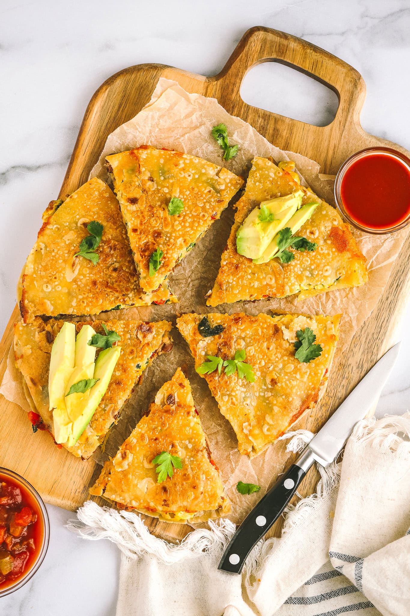 breakfast quesadilla cut up on a platter with avocado