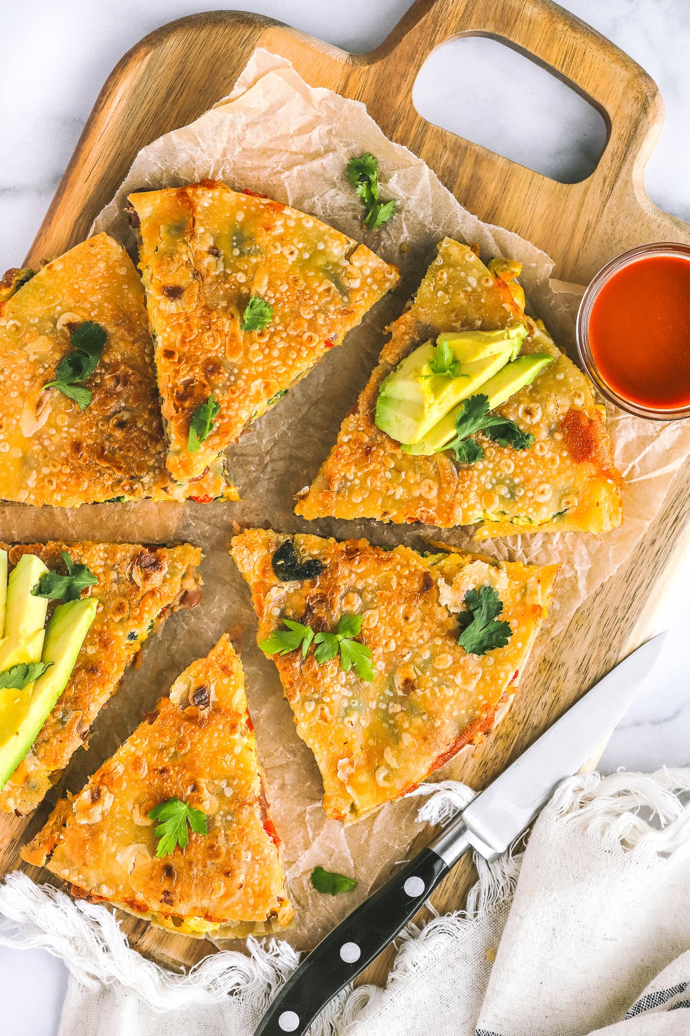 breakfast quesadilla cut up on a platter with avocado