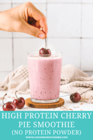 hand placing a cherry on top of the smoothie