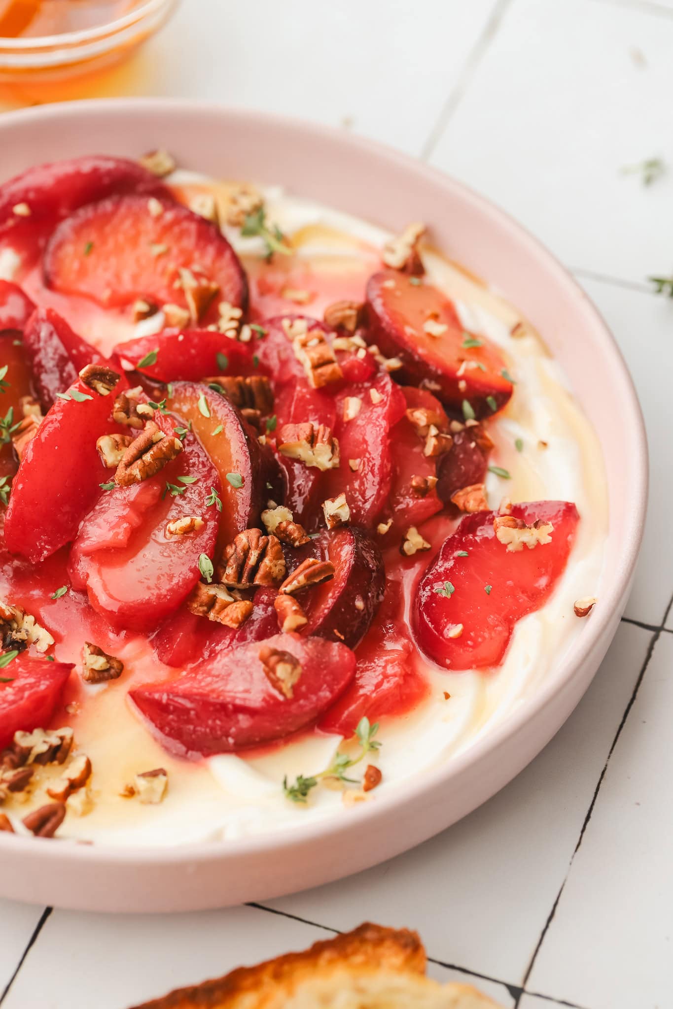 close up of roasted plums on whipped ricotta