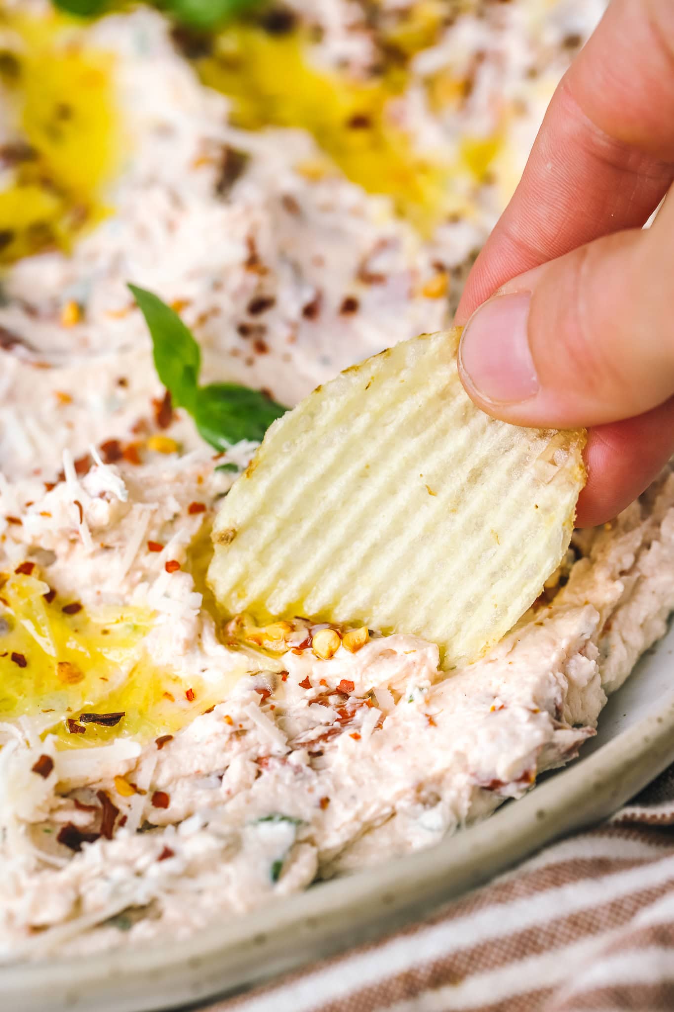 hand dipping a chip in dip