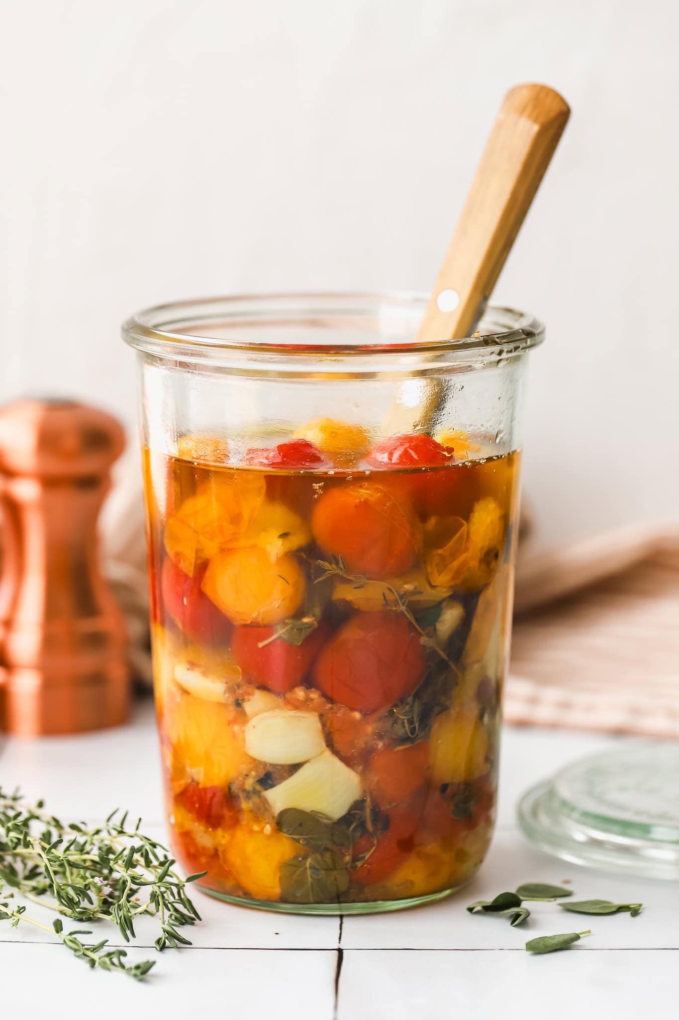 straight on shot of confit cherry tomatoes in a glass jar
