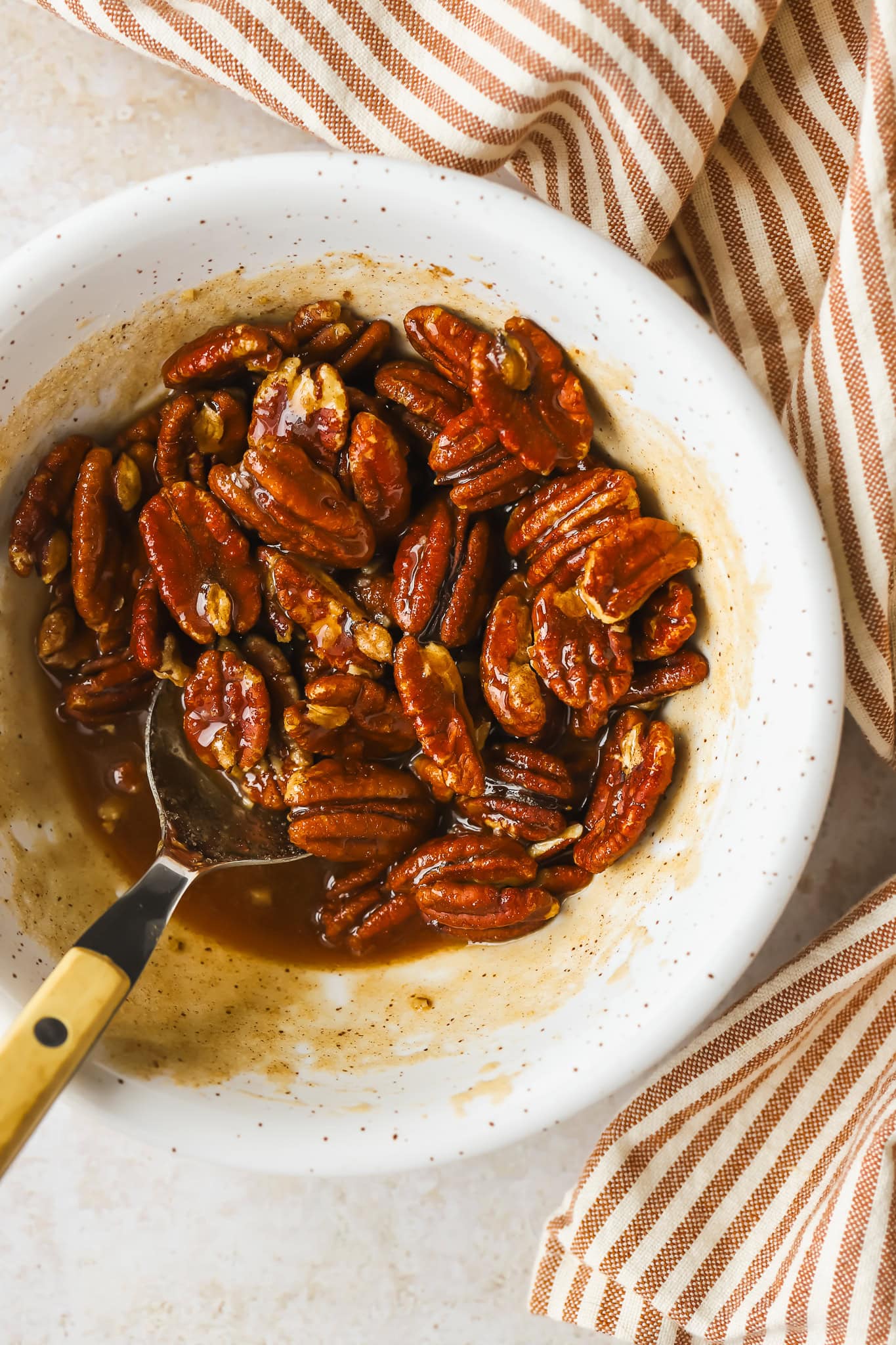 pecans in a bowl with maple syrup