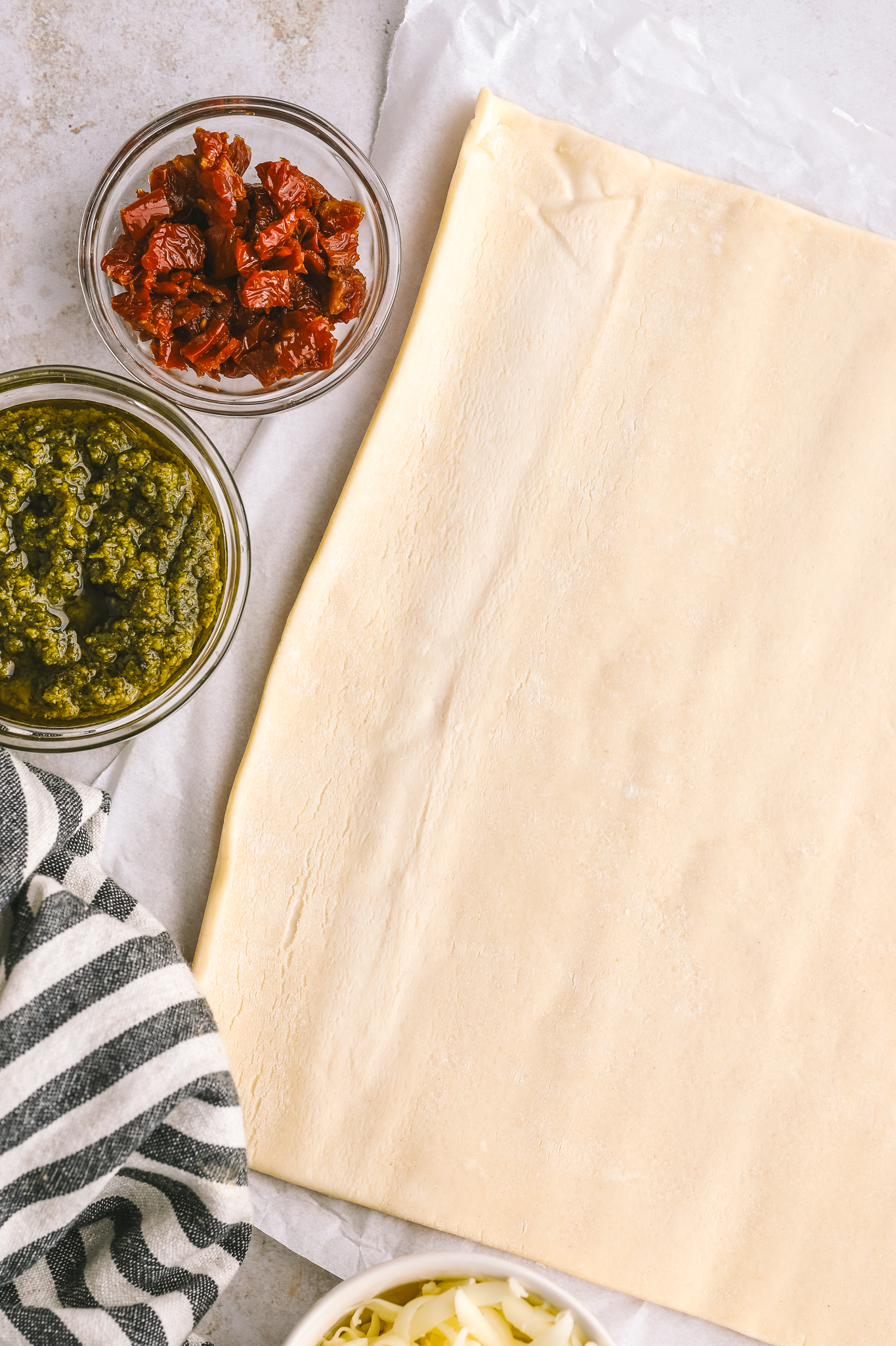 puff pastry, sundried tomatoes in a bowl, basil pesto