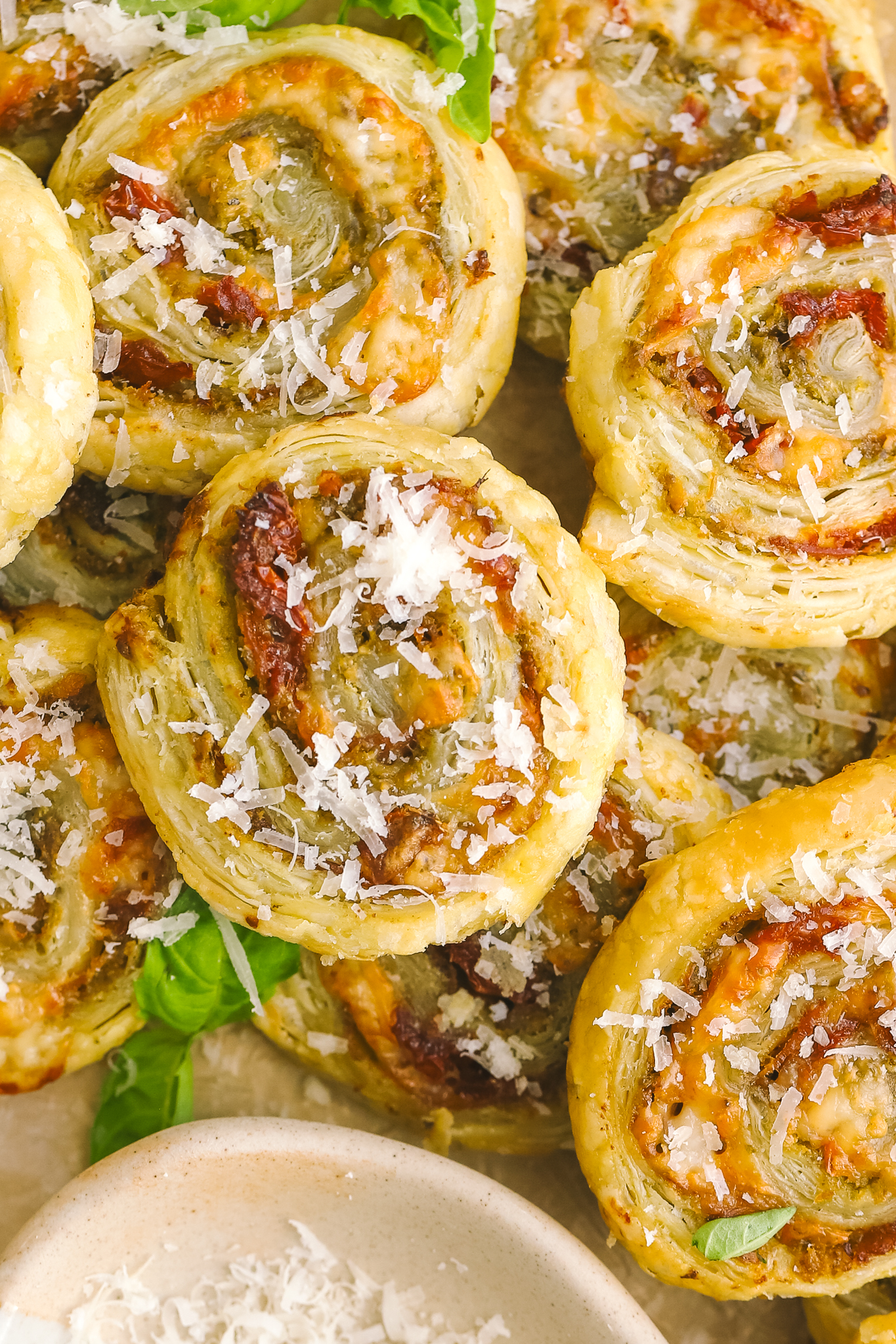 pesto pinwheels with parmesan cheese sprinkled on top