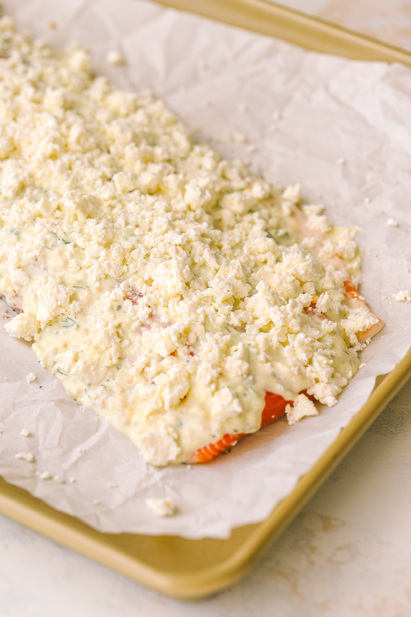 prepped salmon with feta on a baking sheet