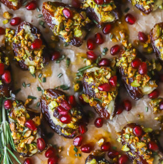 serving tray of stuffed dates with pomegranate seeds and pistachios