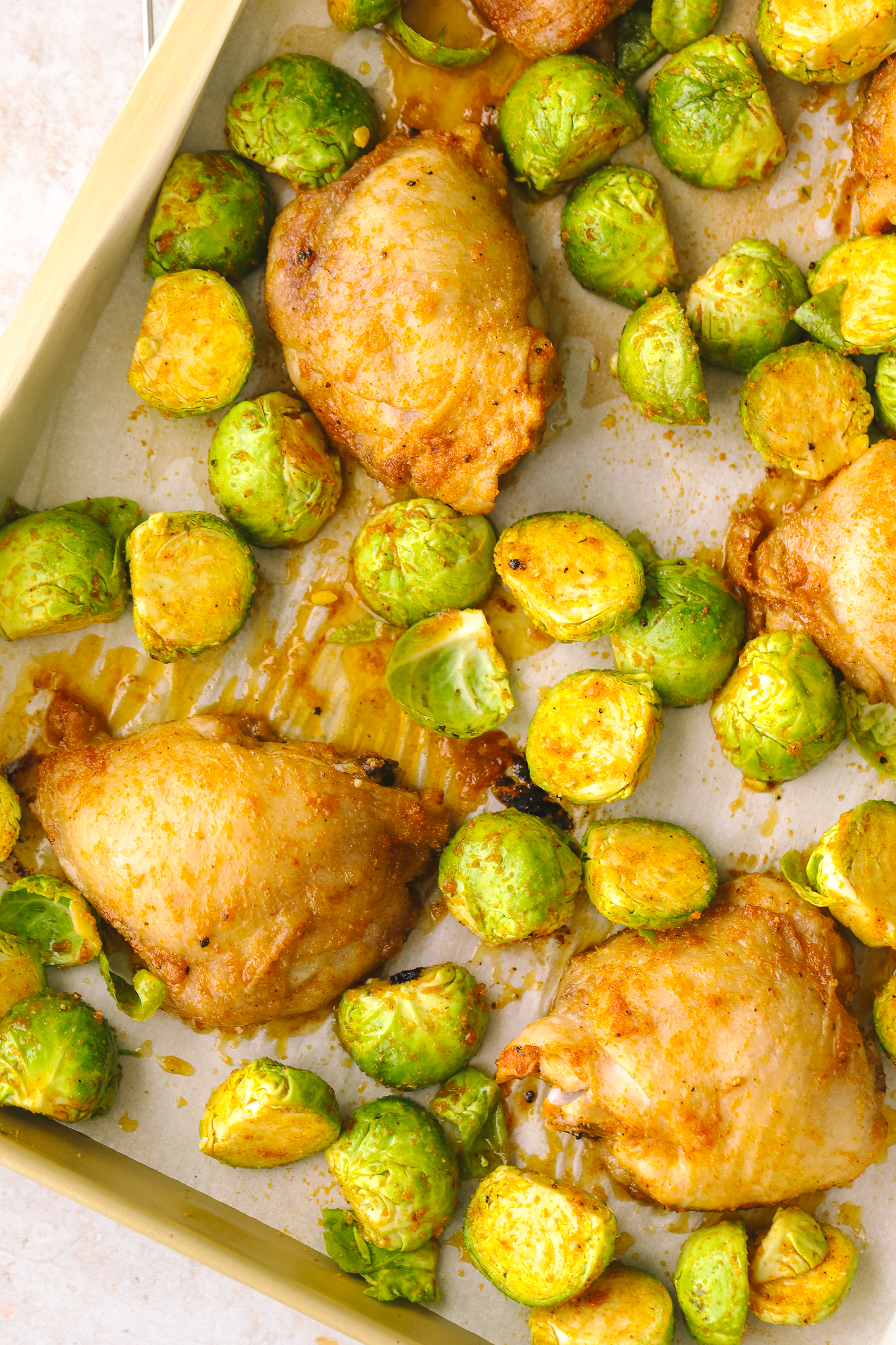halved brussels sprouts and chicken on a sheet pan
