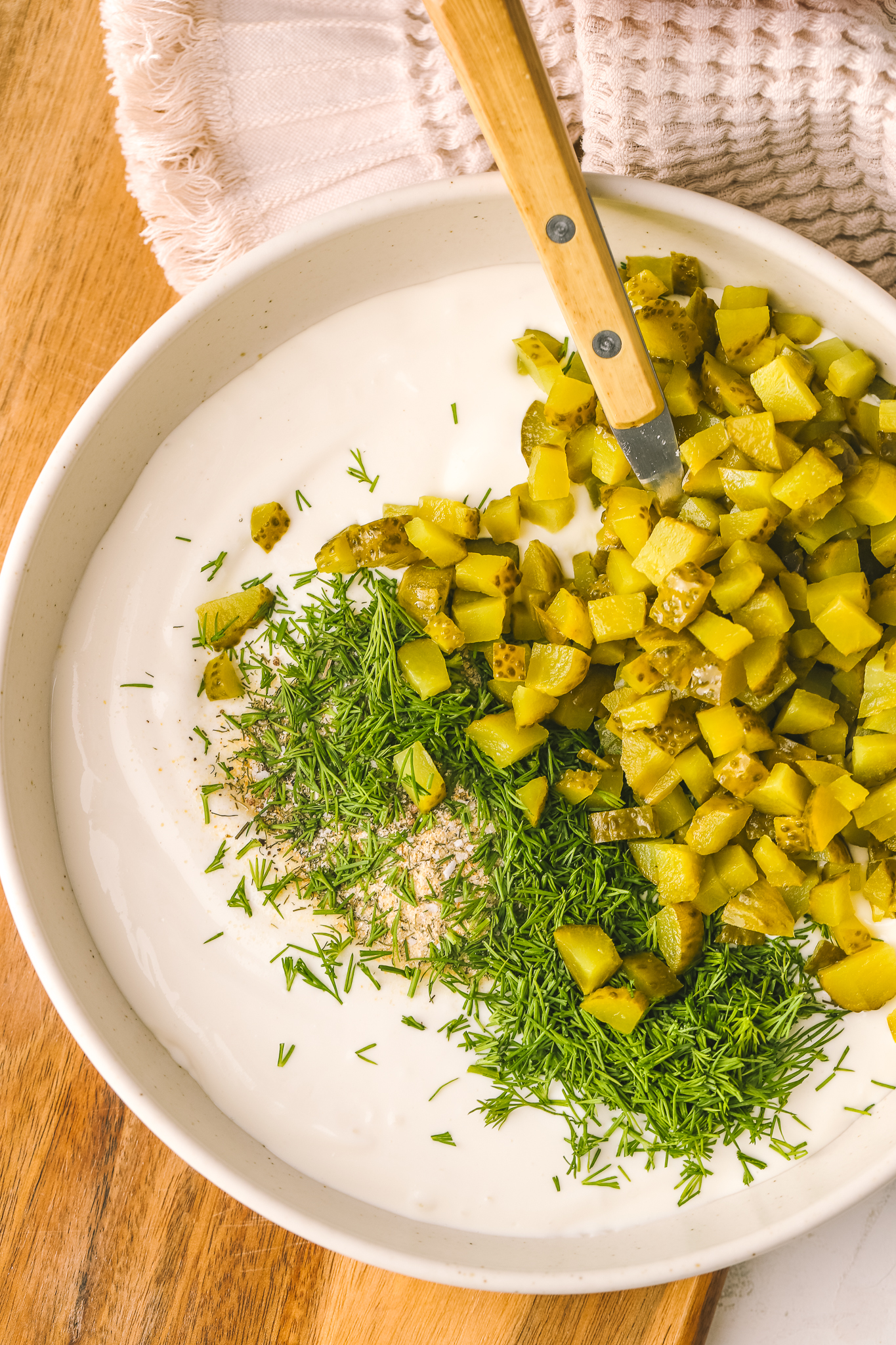 blended cottage cheese, cream cheese and Greek yogurt in a bowl with pickles and dill