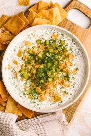 high protein dill pickle dip in a bowl served with pita chips
