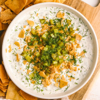 high protein dill pickle dip in a bowl served with pita chips