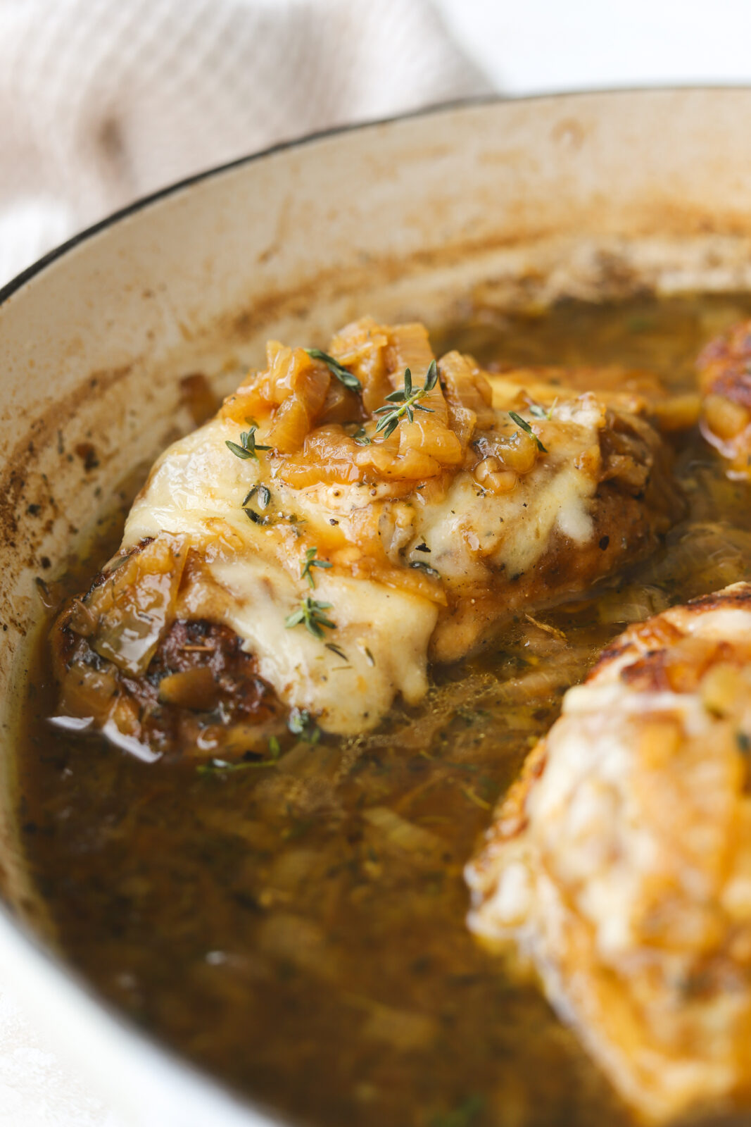 close up of chicken with caramelized onions and melted gruyere cheese
