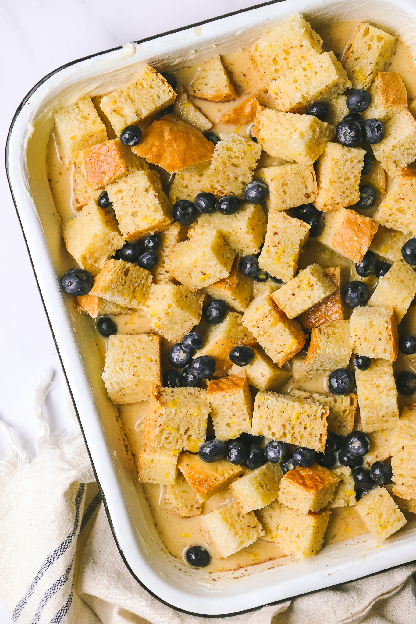 cubes of bread and blueberries in a baking dish