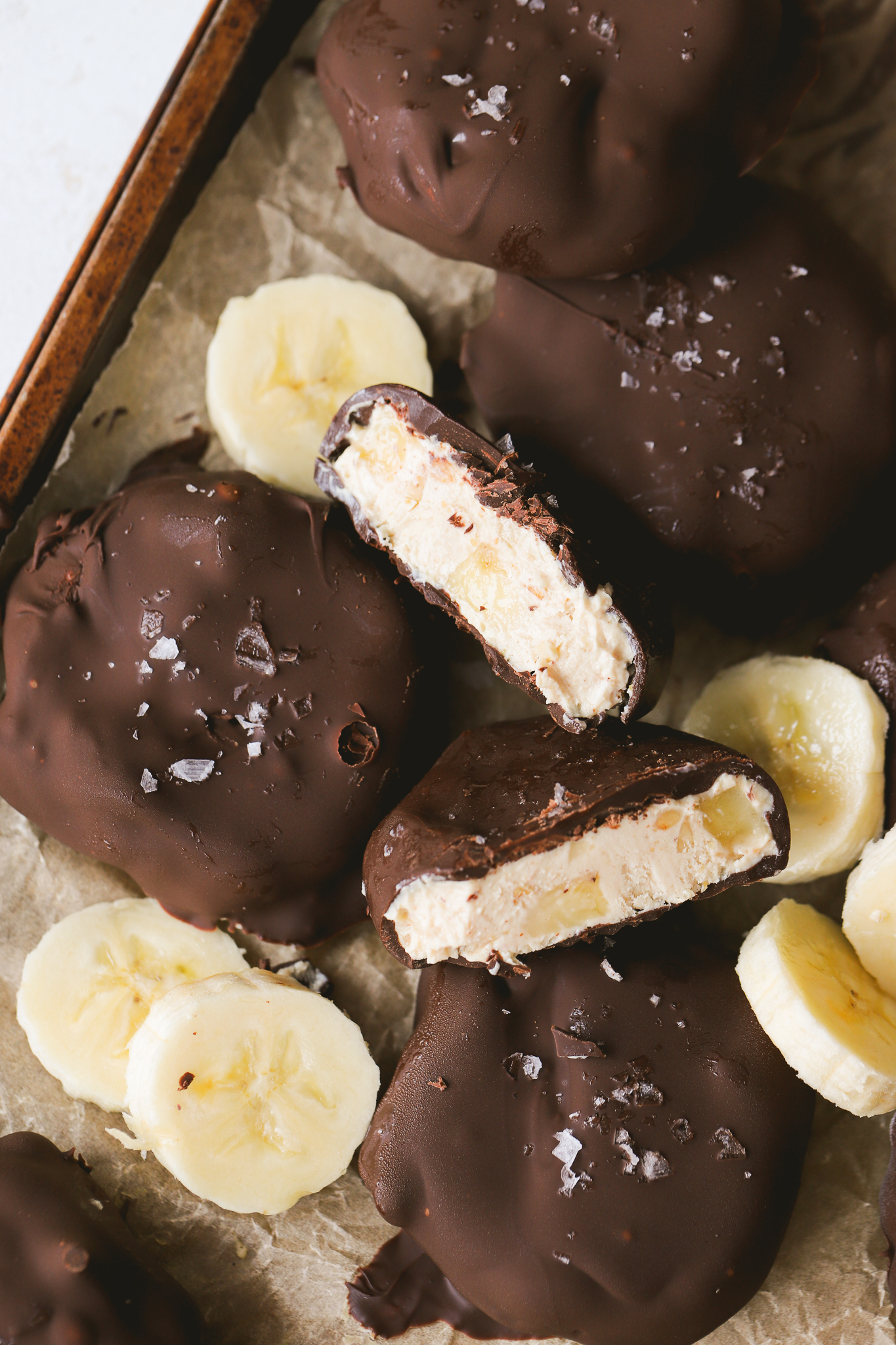 peanut butter banana yogurt clusters cut in half on a baking sheet