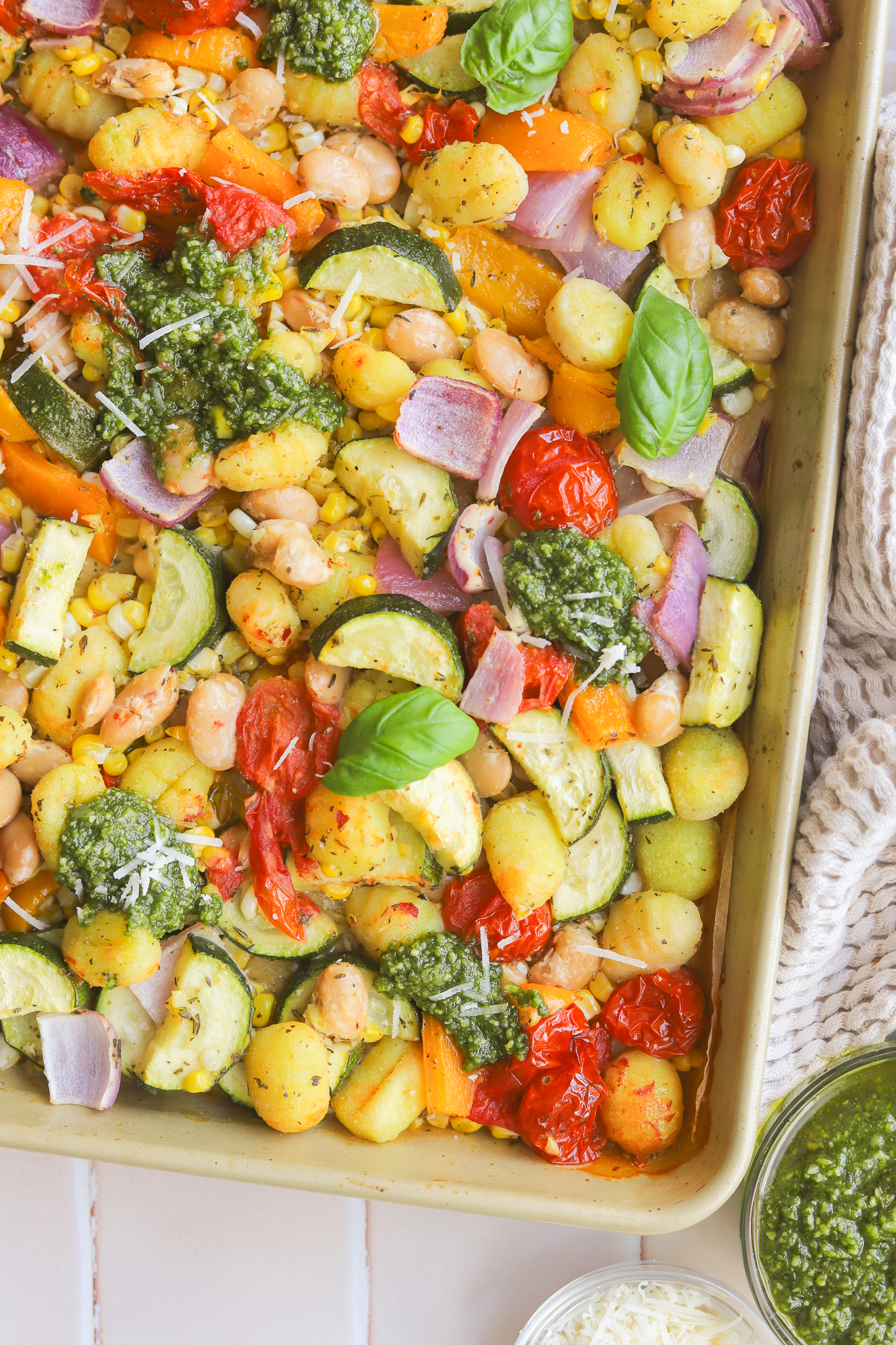 pesto dolloped on a sheet pan gnocchi