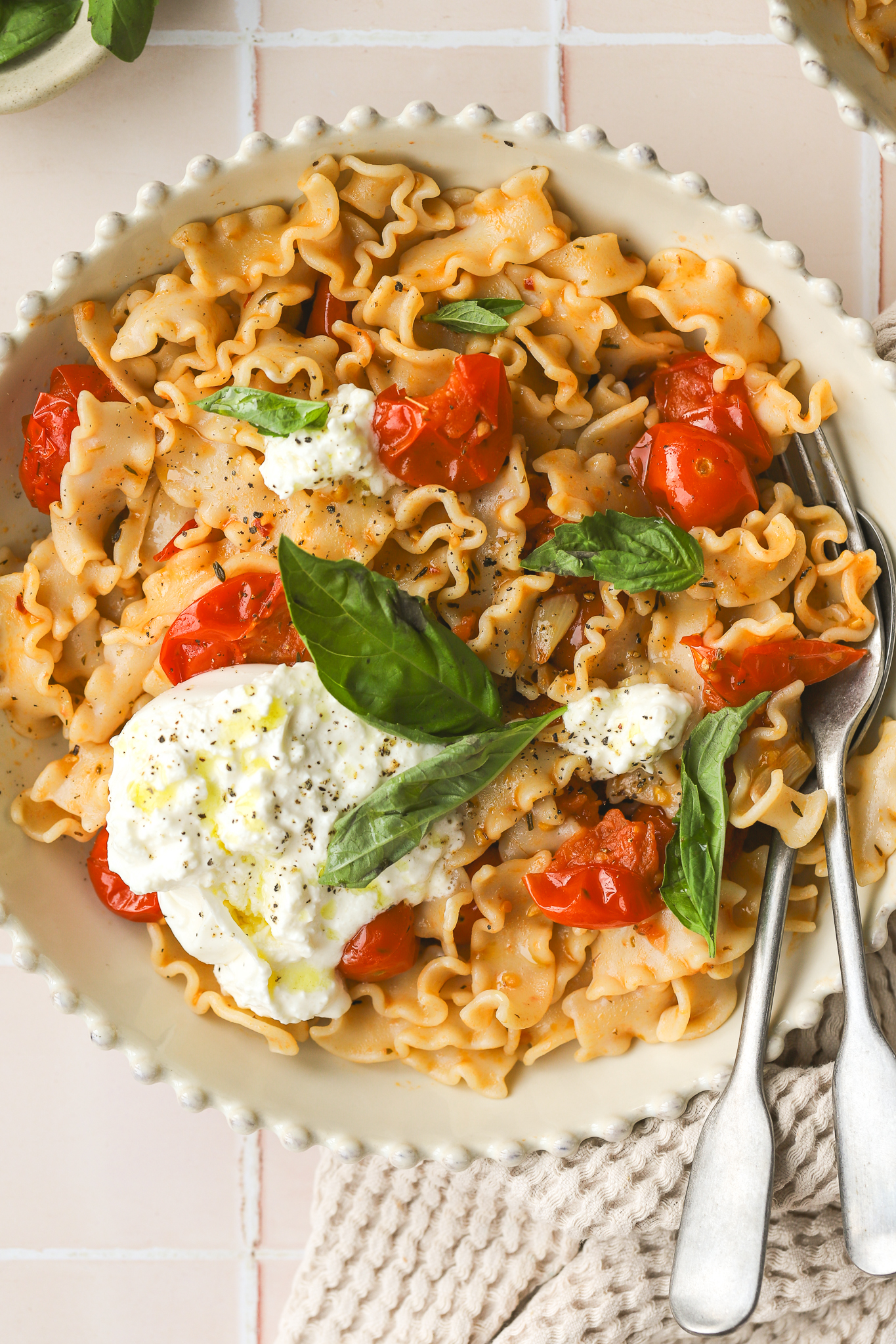 overhead of burst cherry tomato pasta in a bowl
