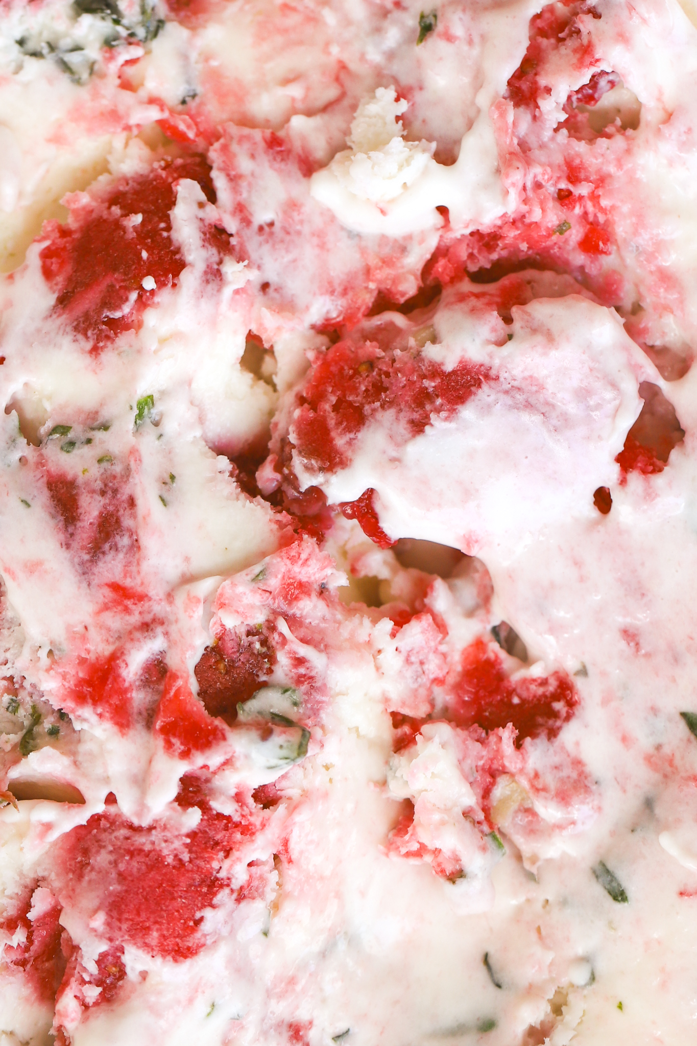 close up of strawberry and basil in ice cream