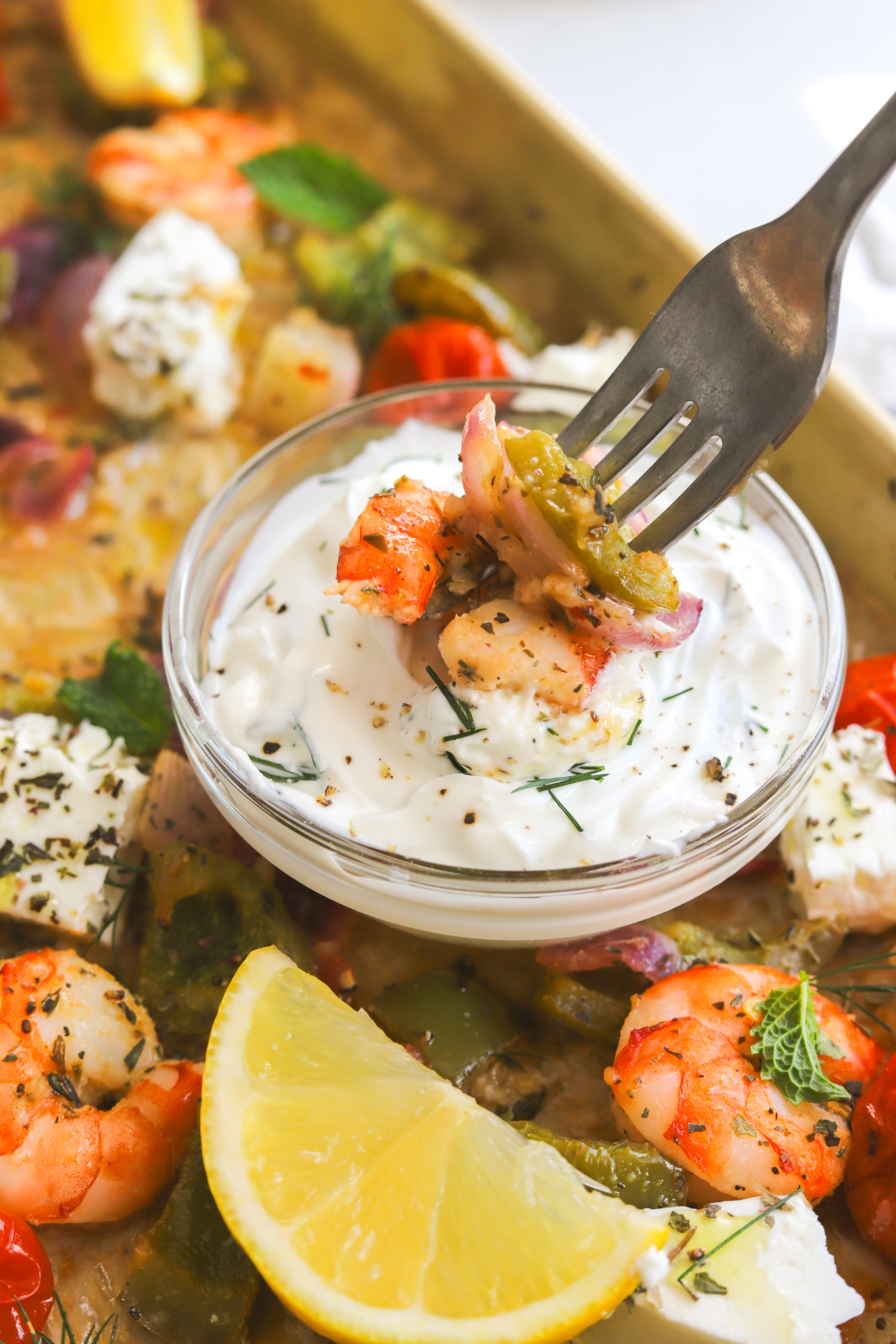 fork with shrimp dipping into yogurt sauce