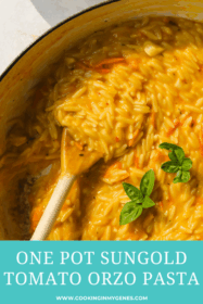 close up of wooden spoon in cooked tomato orzo