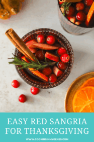 glass of red sangria with oranges, apples, cinnamon stick and rosemary