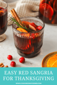 glass of red sangria with oranges, apples, cinnamon stick and rosemary