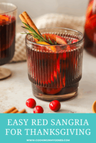 glass of red sangria with oranges, apples, cinnamon stick and rosemary