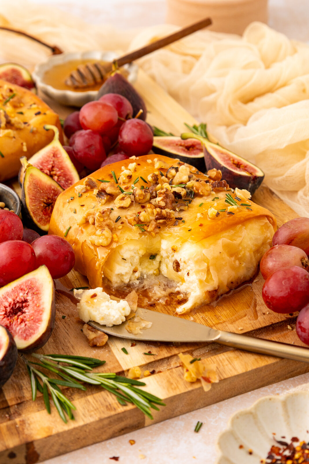 knife cutting into baked feta appetizer