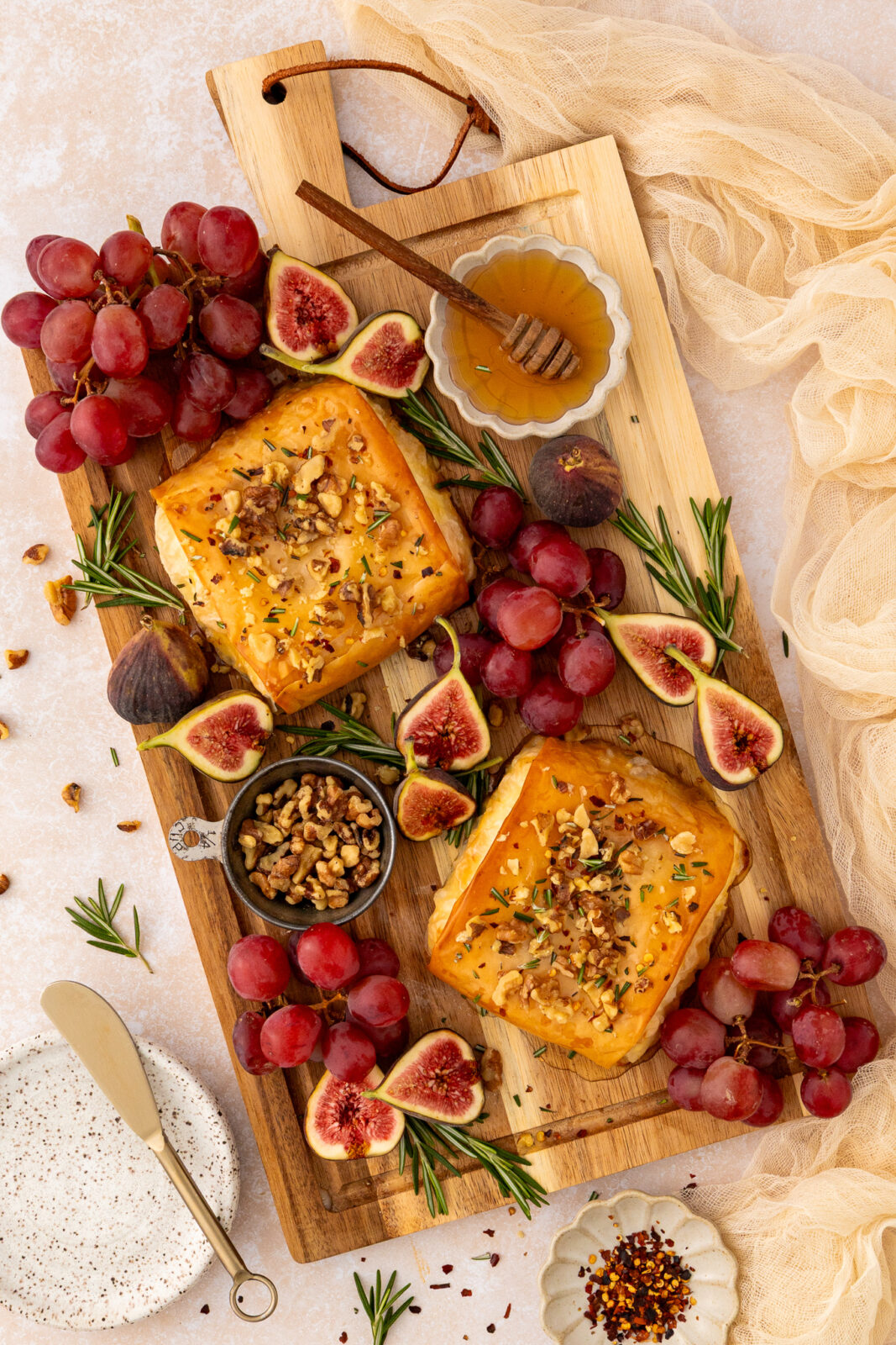 phyllo-wrapped baked feta appetizer on a serving board with seasonal fruits