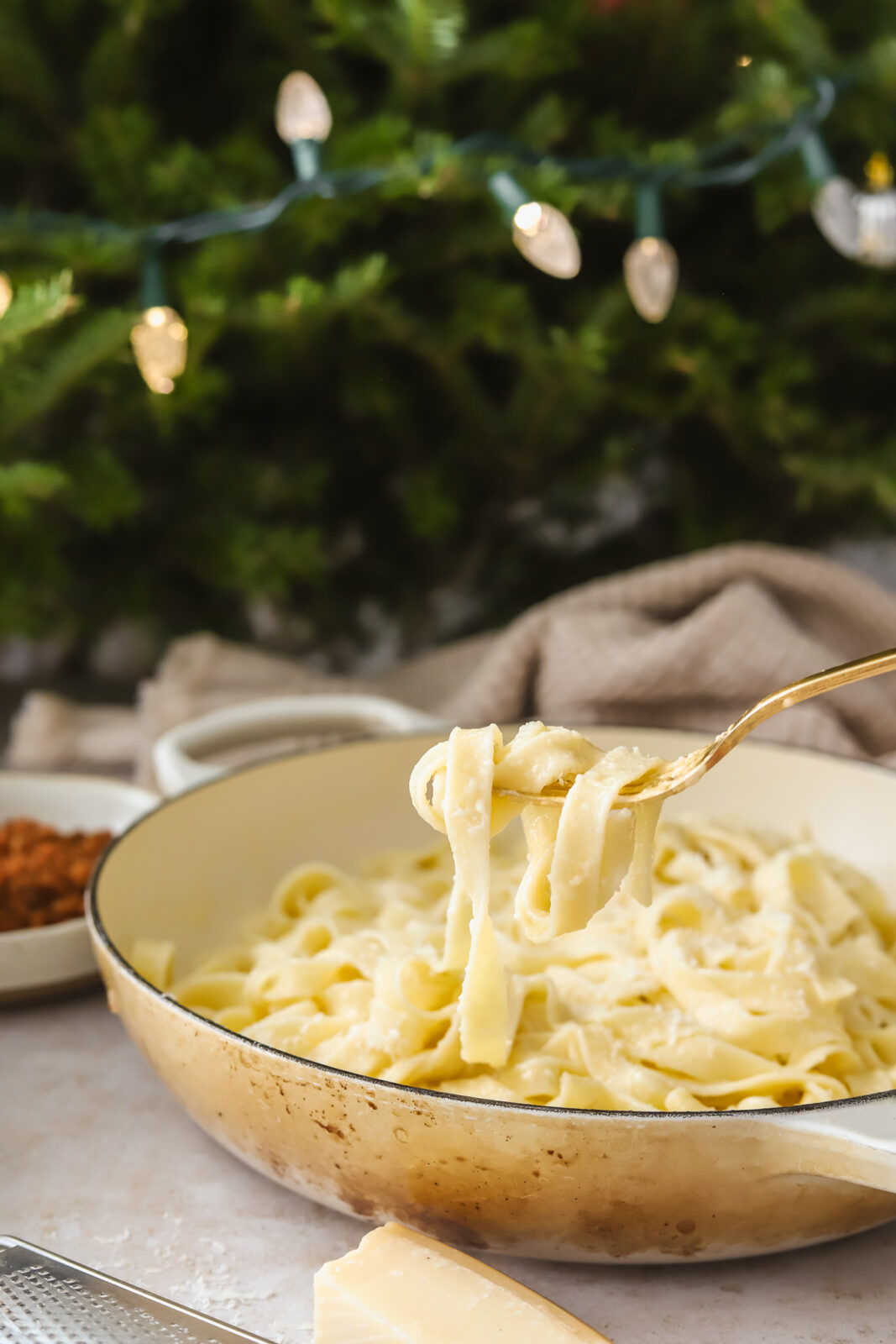 forkful of fettuccine in front of a Christmas tree