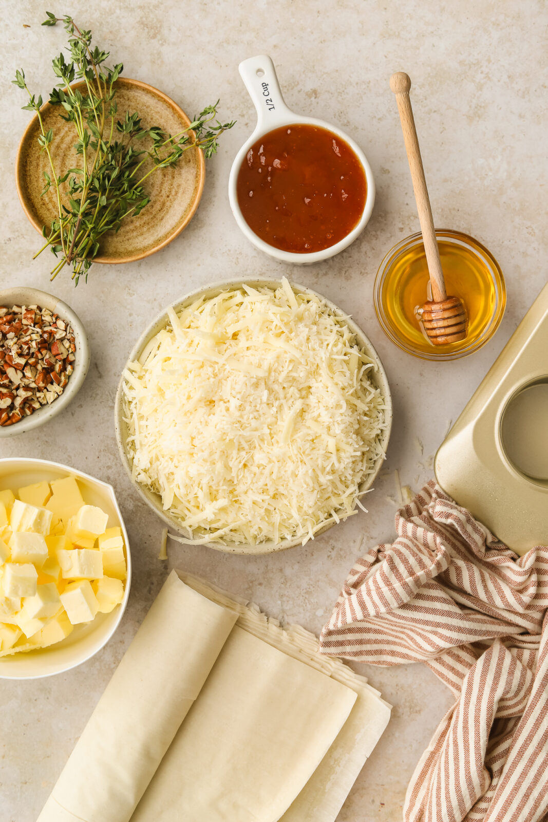 grated cheese in bowls, honey in a bowl, phyllo sheets
