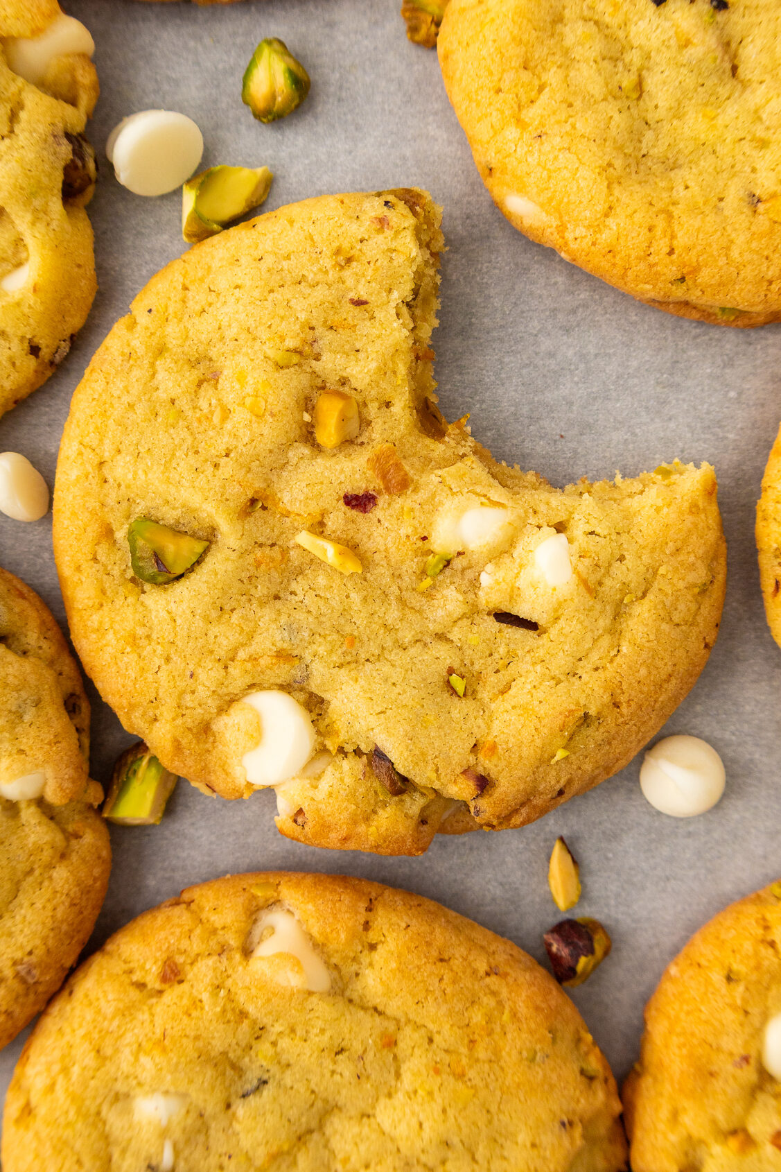 one pistachio orange cookie with a bite out of it