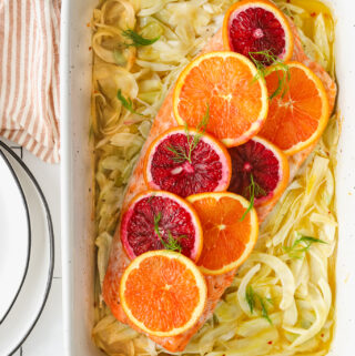 salmon topped with citrus in a baking dish with fennel