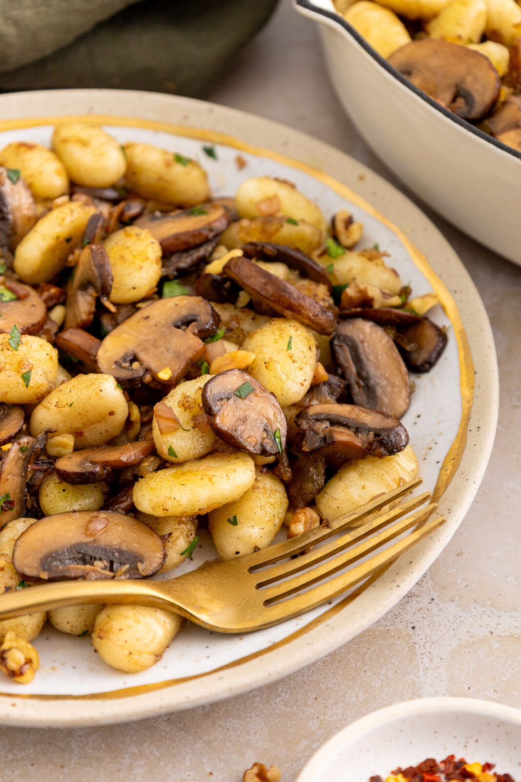 gnocchi and mushrooms side dish on a plate with a fork