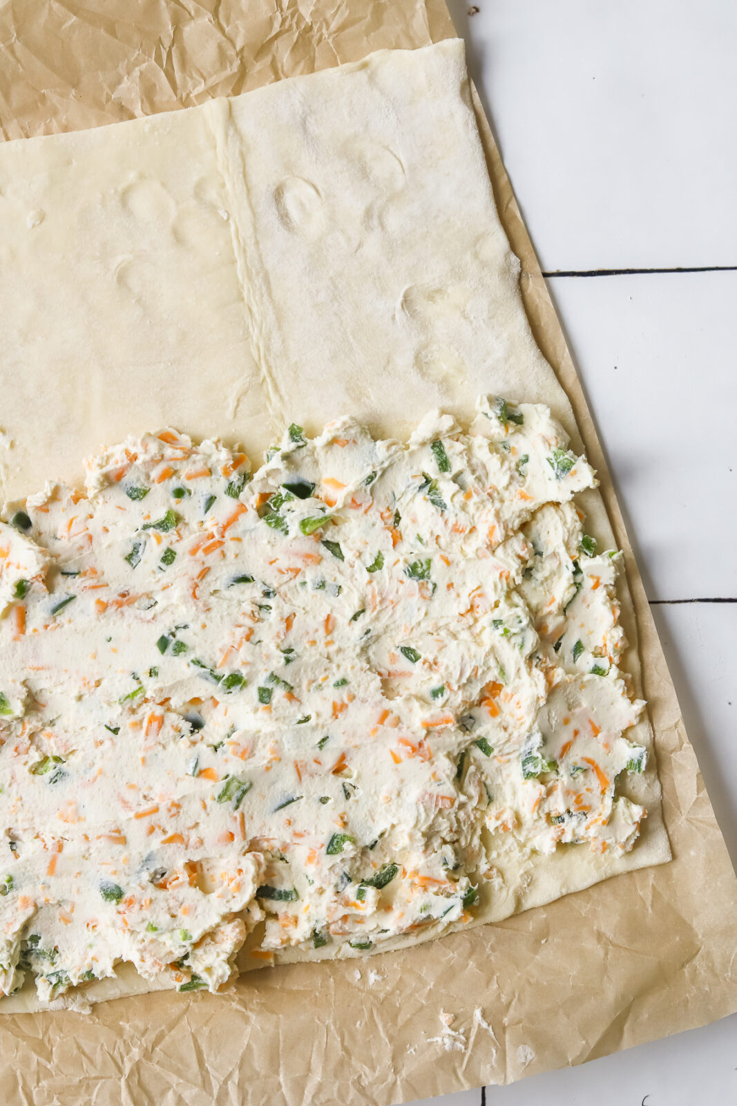 jalapeno popper cream cheese mixture spread on puff pastry