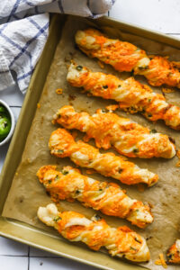 baked jalapeno popper cheese twists on a baking sheet
