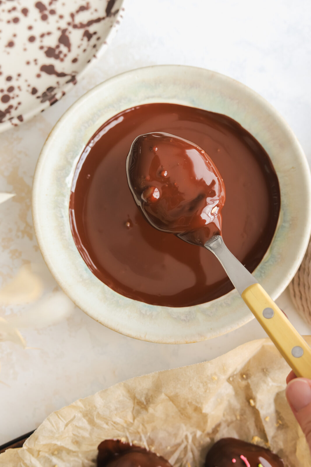 spoon dipping an Easter egg into chocolate