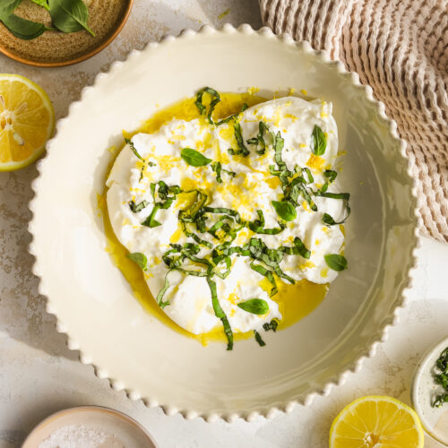 burrata appetizer with fresh basil and lemon zest in a bowl